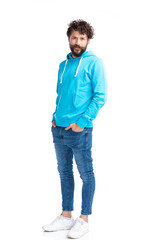 Naklejka premium sexy young man in blue sweatshirt holding hands in pockets