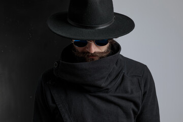 mysterious bearded man with black hat looking down
