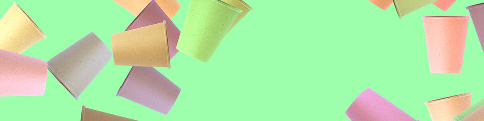 colored paper disposable cups on a pastel green . holiday card, banner