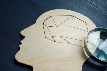 Mental health and memory problems. Head with a puzzle inside and a magnifying glass.