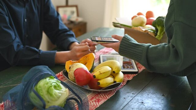 オンラインスーパーマーケットで野菜の配達を注文する男女