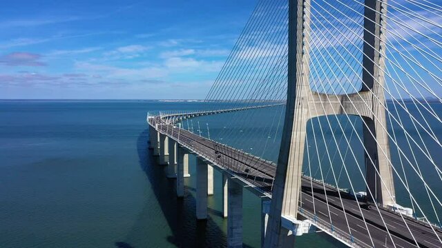 Aerial view of cars driving over the Vasco da Gama, the longest bridge in Europe - rising, drone shot