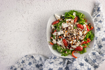Fresh vegetables salad with feta cheese and roasted sunflower seeds, copy space