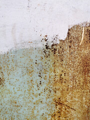 texture of an old metal garage wall exposed to weather and with rust and white paint
