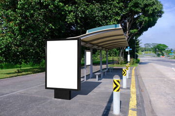 Blank advertising poster banner mockup at empty bus stop shelter by main road, greenery behind;...