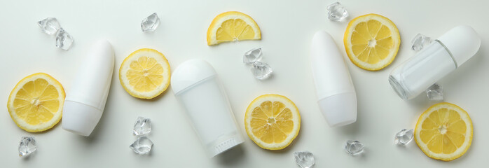 Blank deodorants, lemon slices and ice cubes on white background