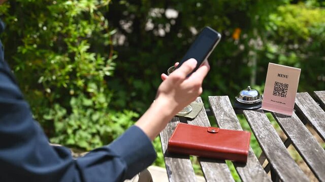 カフェのメニューをQRコードで読み取る男性