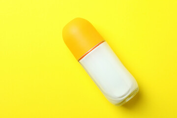 Blank roll-on deodorant on yellow background, space for text