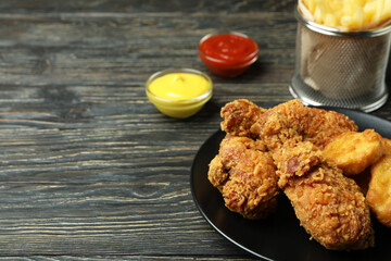 Concept of tasty eating with fried chicken on wooden background