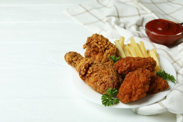 Concept of tasty eating with fried chicken on white wooden background