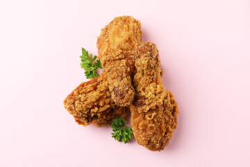 Tasty fried chicken on pink background, close up