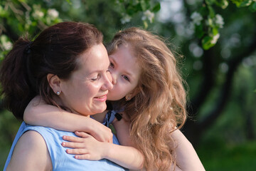 Fototapeta premium nature scene with family outdoor lifestyle. Mother and little daughter playing together in a park. Happy family concept. Happiness and harmony in family life.