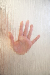 female hand behind frosted glass shower screen