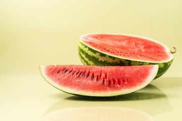 Juicy ripe fresh piece of watermelon. Summer pastel green background, side view