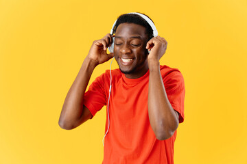 african man wearing headphones fun yellow background