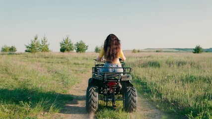 Free woman ride a Quad bike in park in summer on a dirt road. Off-road ATV adventure. The girl...