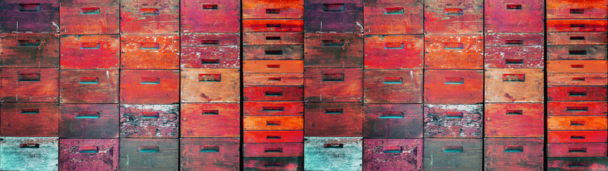 Beekeeper beekeeping background banner panorama wallpaper - Abstract wall texture made of many old rustic pink red orange painted colored wooden beehives stacked on top of each other
