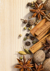 Cooking spices, anise, cardamom, cinnamon rolls, nutmeg, allspice peas. Close-up top view of various spices. Spectacular wood background.