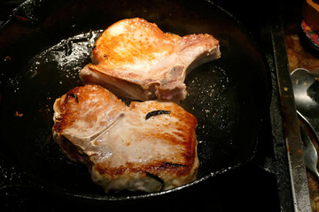 Shot of the wine-braised pork chops cooked in a pan in the kitchen.