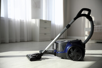Modern vacuum cleaner on floor in bedroom - obrazy, fototapety, plakaty