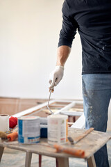 Young adult man painting on a DIY budget renovation of his new home apartment.