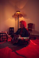 Woman playing acoustic guitar in a retro vintage room.