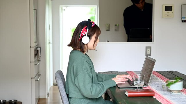リモートワークをする女性と家事をする男性	