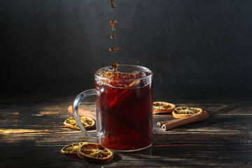 A glass mug with pouring black tea