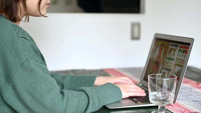 自宅で仕事をする女性と家事をする男性	