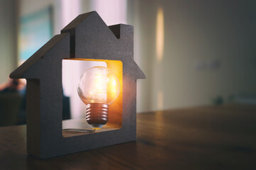 Wood house with Light bulb. energy concept or invention