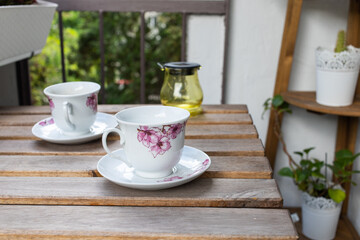 bright small apartment terrace in summer with flowers and coffee table