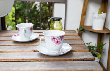 bright small apartment terrace in summer with flowers and coffee table