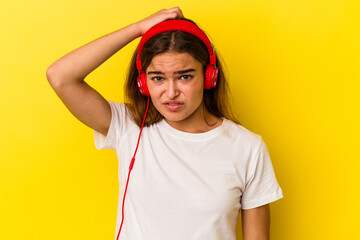 Young caucasian woman listening to music isolated on yellow background being shocked, she has remembered important meeting.
