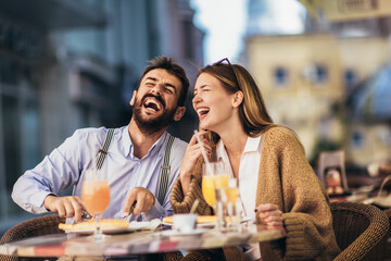 Smiling Couple On Date Enjoying Pizza In Restaurant Together