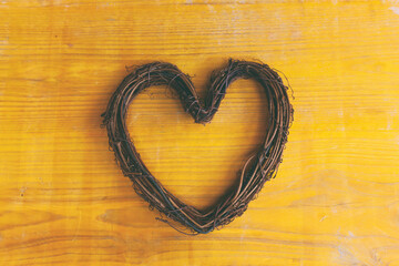 woodem heart shape on yellow background