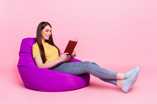 Full length profile side photo of young girl happy positive smile read book sit chair bean isolated over pastel color background