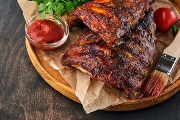 Grilled and smoked pork ribs with barbeque sauce on an old vintage wooden cutting board. Tasty snack to beer. Closeup image.