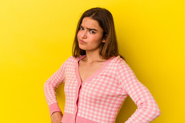 Obraz premium Young caucasian woman isolated on yellow background frowning face in displeasure, keeps arms folded.
