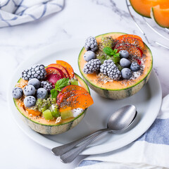 Fruit salad with yogurt in carved melon cantaloupe bowl