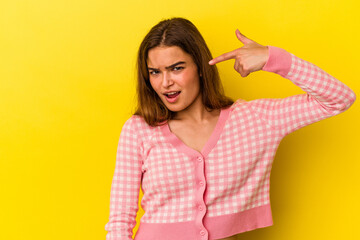 Young caucasian woman isolated on yellow background person pointing by hand to a shirt copy space, proud and confident