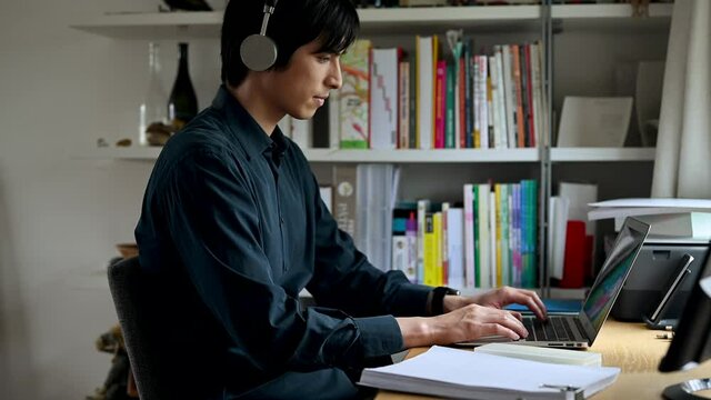 家から会社のリモート会議に参加する男性