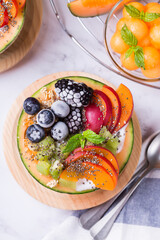 Fruit salad with yogurt in carved melon cantaloupe bowl