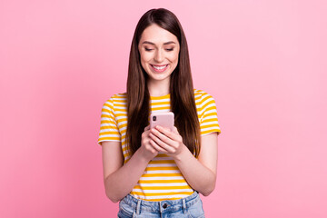 Photo of interested young millennial lady look telephone wear orange t-shirt isolated on pastel pink color background