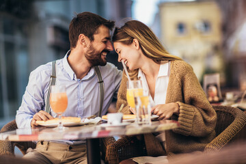 Smiling Couple On Date Enjoying Pizza In Restaurant Together