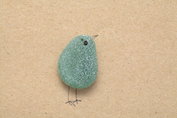 stylish textured craft paper background funny little bird made of a piece of seaglass
