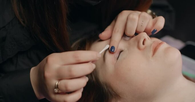 Lashmaker does the eyelash lamination procedure for the client in the beauty salon, cosmetic services, beauty care procedures, 4k 60p Prores HQ