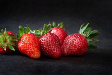 Ripe red strawberries on black background