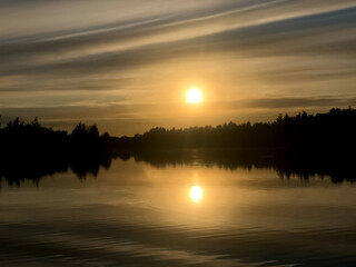 Fototapeta premium Fog over the water surface of the lake at sunset in summer