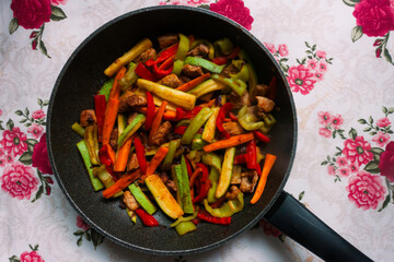meat with vegetables in a pan on a table