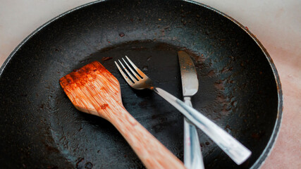 dirty fork and knife in a dirty pan